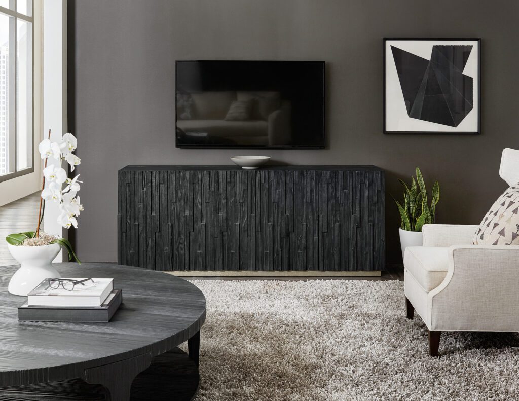 a black entertainment center with a flat TV and a wall art 