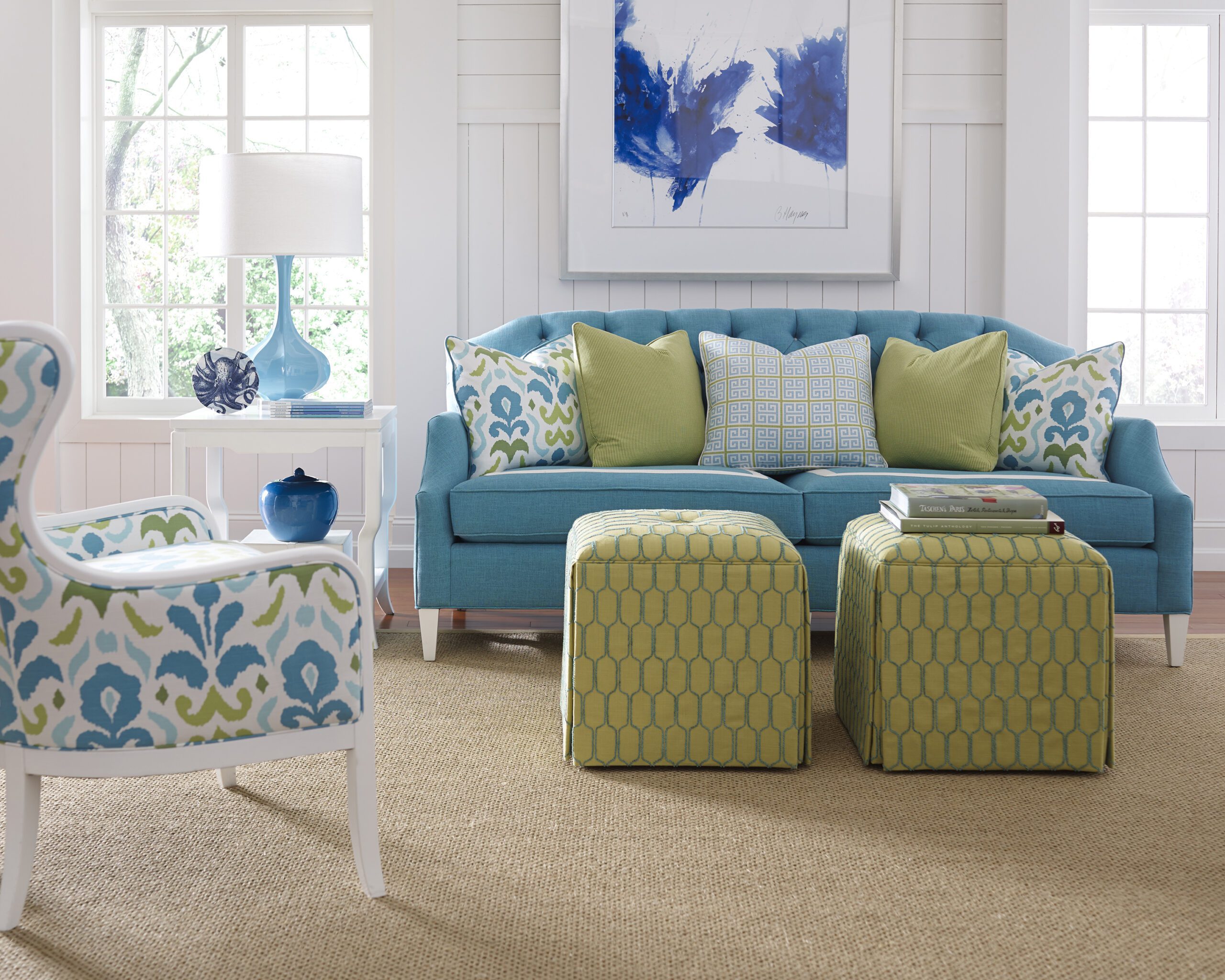 a blue couch with green ottomans in a living room